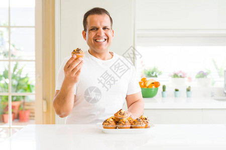 中年男子在家里吃巧克力薯片松饼图片