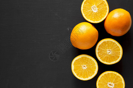 黑底顶视角上方的橙子和整片橘子被减半背景图片