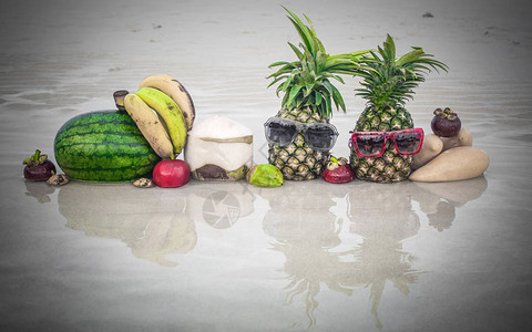沙滩上奇异和多彩热带新鲜水果的关闭有墨镜的时髦菠图片