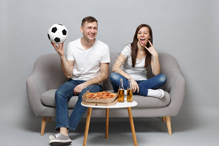 有趣的情侣女人男足球迷用足球描绘出在灰色背景上孤立的重金属摇滚标志图片