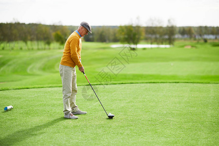 高尔夫俱乐部紧贴草地球场的球面上站在绿草坪上图片