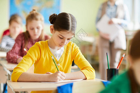 严重忙碌的有毛包头发的学生女孩专注于填空测验图片