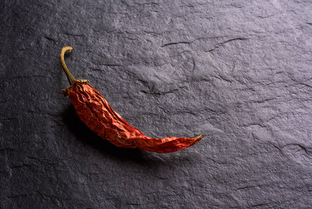 深色石背景中的干红辣椒背景图片