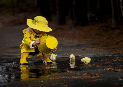 一个小孩在雨中玩耍而小妞图片