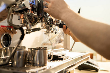 无法辨认的男咖啡师使用浓缩咖啡机冲泡咖啡的特写图片