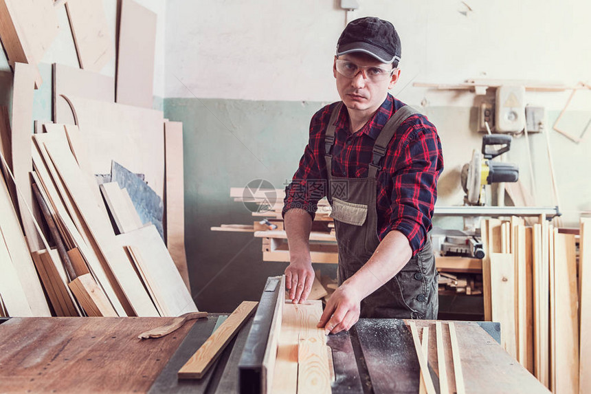 木匠工人用圆锯砍木板职业木工和图片