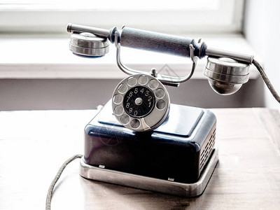 古老的变型黑金银电话旧木制桌高清图片