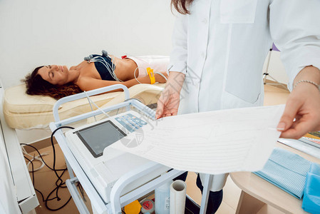 有心电图设备的医生在诊所对病人进行心电图测试诊断保图片