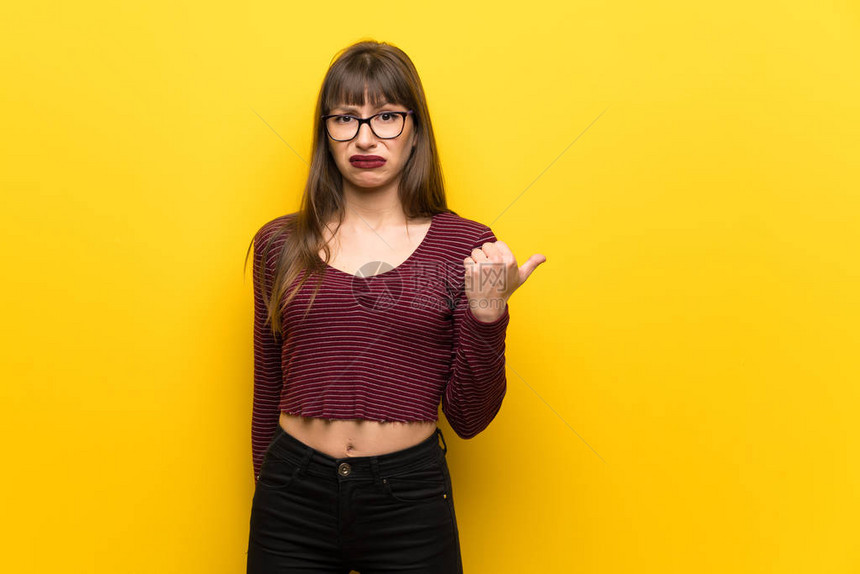 在黄色墙上戴眼镜的女人不开图片