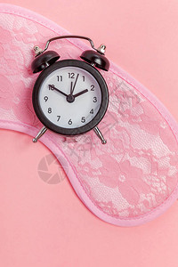 闹钟隔离在粉红色柔和的彩色时尚背景上背景图片
