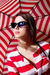 风格红发女人戴着红色条纹雨伞的太阳镜图片