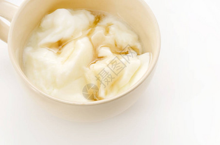 白色背景汤杯中的低聚糖酸奶高清图片