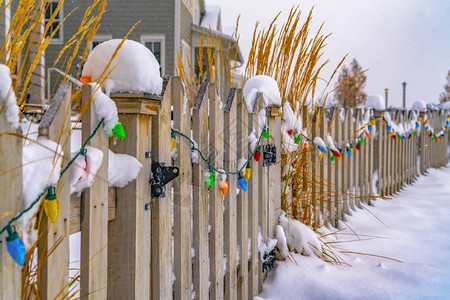 白雪皑的木门和栅栏上的彩灯图片