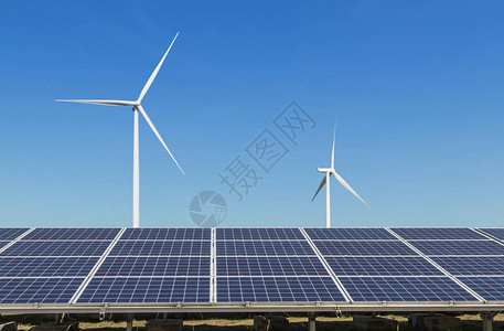 在混合发电厂系统中发电的多晶硅太阳能电池板和风力涡轮机的行阵列从自然中提取可替背景图片