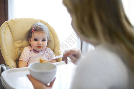 母亲喂养一个可爱的幼儿女孩健图片