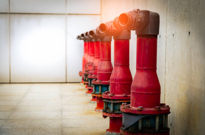混凝土建筑水泥地板上的消防安全泵消防系统的雨淋系统管道防火混凝土墙前的红色消防泵高图片