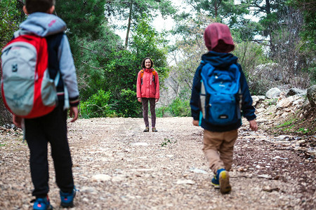 孩子们跑向妈男孩和他的母亲和兄弟在森林里散步一个女人抓住她的儿子女图片