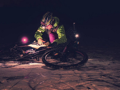骑自行车者在夜里阻止冰冻湖上的自行车图片
