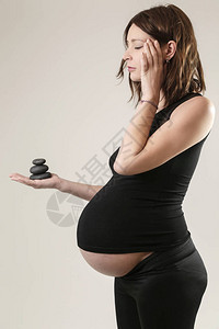 怀孕妇女将黑金石放松背景图片