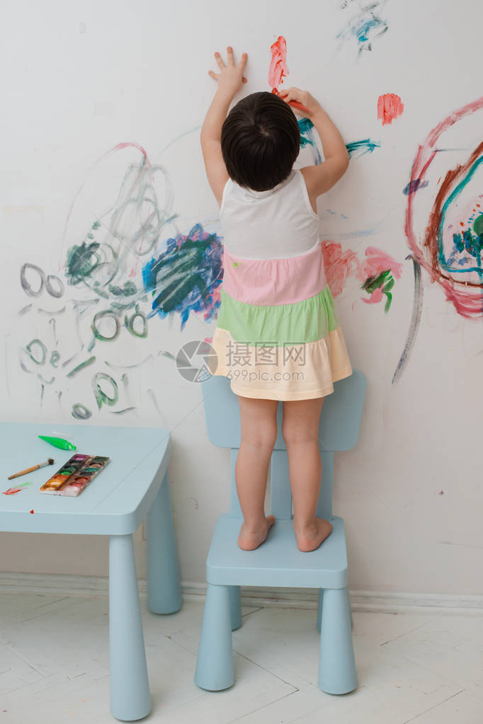 一个3岁的小女孩在她房间的墙上用油漆和刷子画了一个拱形的样子顽皮的孩子图片
