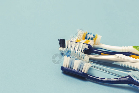 蓝色背景上的几种不同用过的牙刷牙刷改变概念口腔卫生大而友好的家图片