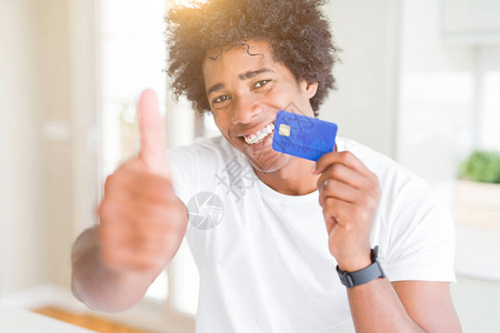 非洲裔美国人拿着信用卡开心地笑着做好手势图片