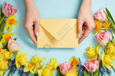 黄色信封粉色郁金香黄色水仙花和蓝色风信子的女图片