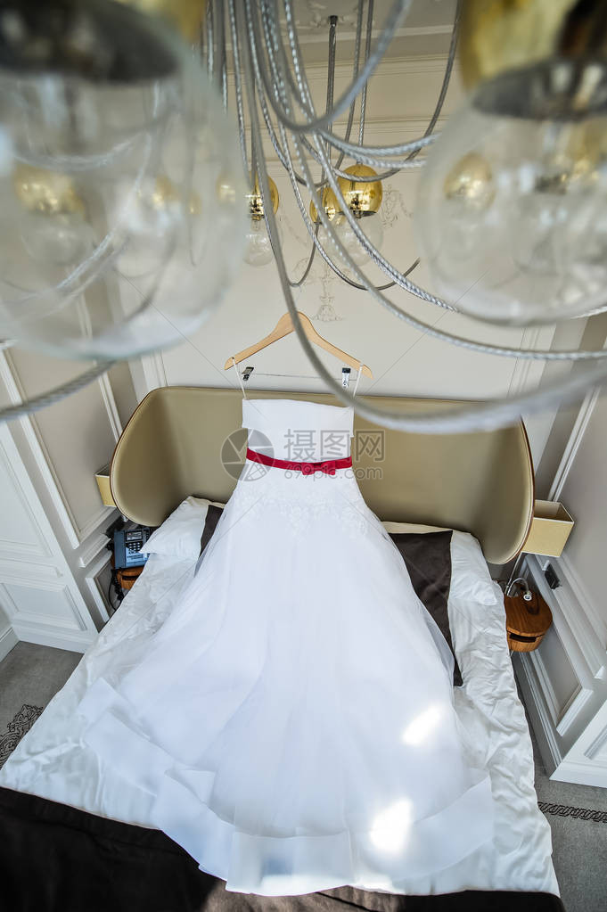 新娘的白婚礼服挂在酒店房间图片