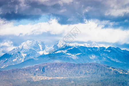 斯洛文尼亚卢布尔雅那的朱利安阿尔卑斯山雪景观与自然背景山顶有云彩和天空视图与蓝色高山足迹风景的岩石全景背景图片