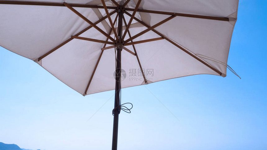 白色织物颜色纹理沙滩伞和棕色木三脚架图片