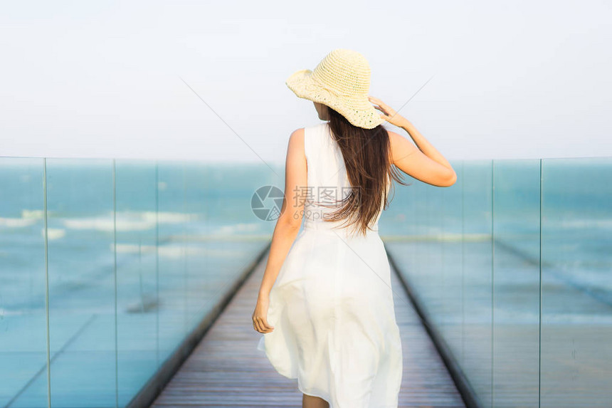 美丽的年轻亚洲女在海滩和洋上欢笑快乐图片