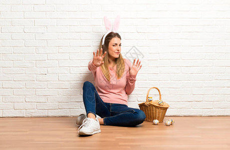 在复活节假期穿兔子耳朵的年轻女子有点紧张和害怕图片
