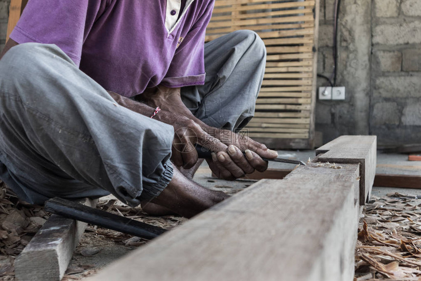 在第三世界的传统木工店中使用手动工具的木匠警告手的特写繁重的劳动密图片