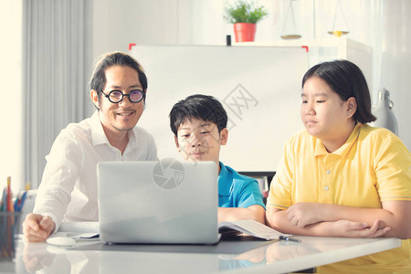 辅导室儿童在课堂上与老师一起在笔记本电脑上学习亚洲儿童在家和背景