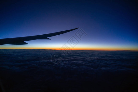 空中飞机翼飞越云层的景象和日出时飞过陆地自然和旅行概图片