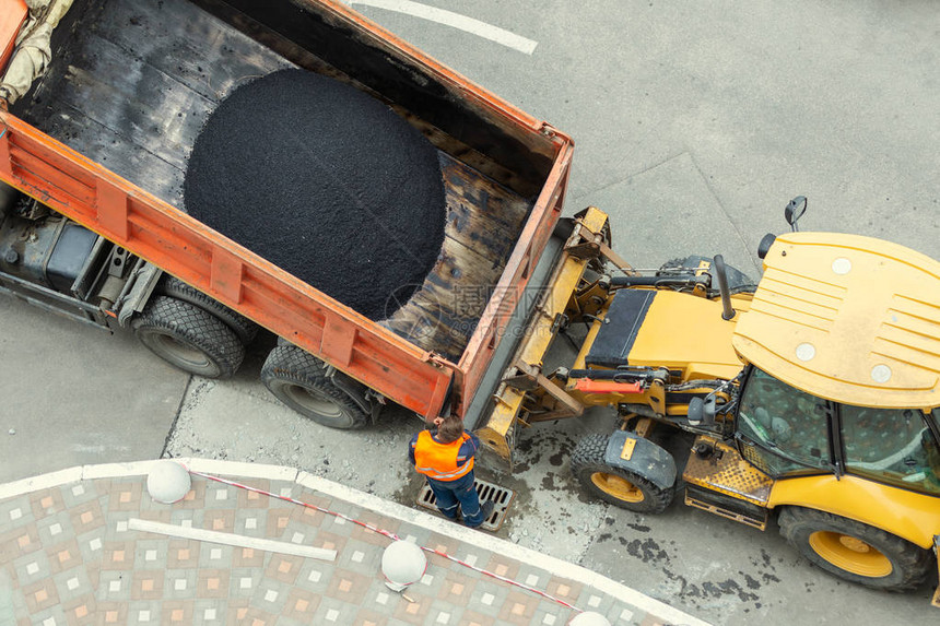 重型工业倾卸卡车卸下热沥青城市道路建图片