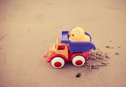 沙滩上的黄色子玩具和彩色汽车儿童图片