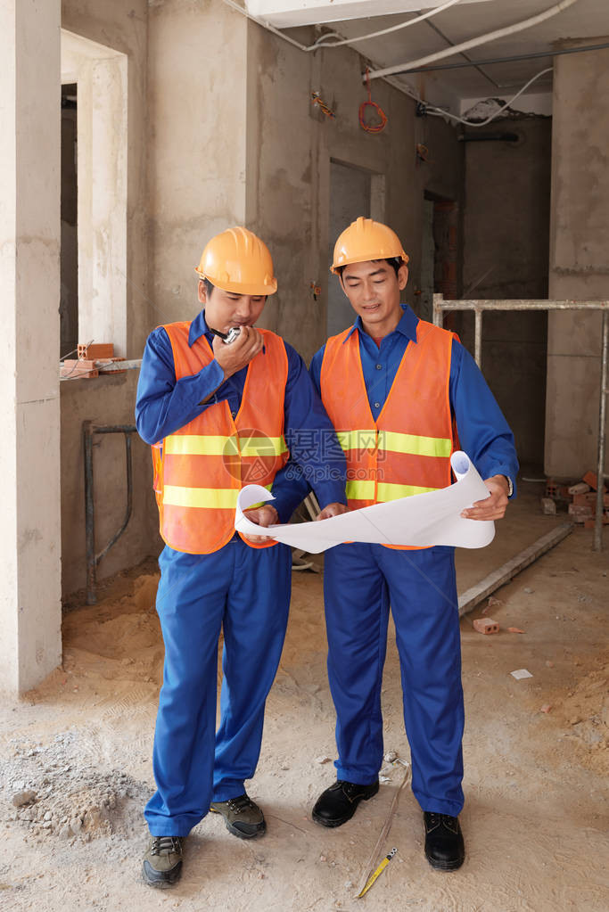 越南建筑工人检查蓝图图片