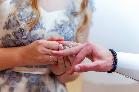 新娘和新郎的婚姻手与结婚戒指新娘手把结婚戒指放在新郎手指上爱的宣言图片