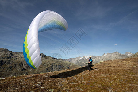 年轻的滑翔伞飞行员练习他的滑翔伞在风中拉起图片