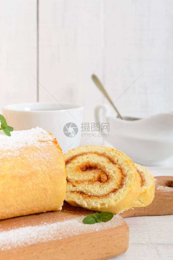 美味的饼干卷加杏仁果酱和白木桌上的茶杯早餐甜图片