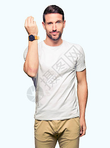 身穿随意白色T恤衫的帅男子用手和指做意大利式手势图片