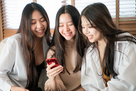 年轻商业团体朋友使用智能手机坐在沙发图片