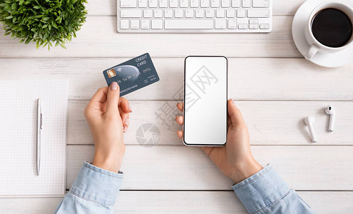 互联网概念中的在线购物使用信卡和空白智能手机白色木桌背景图片