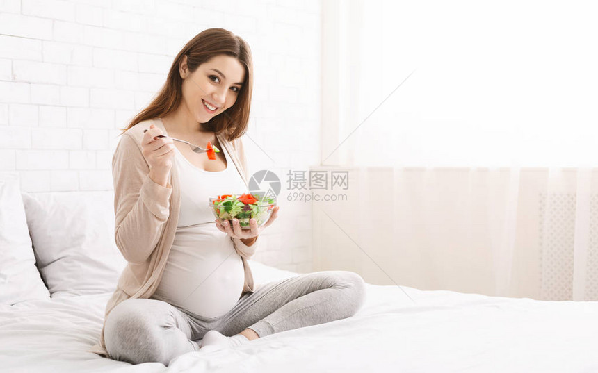 快乐的孕妇吃天然蔬菜沙拉图片