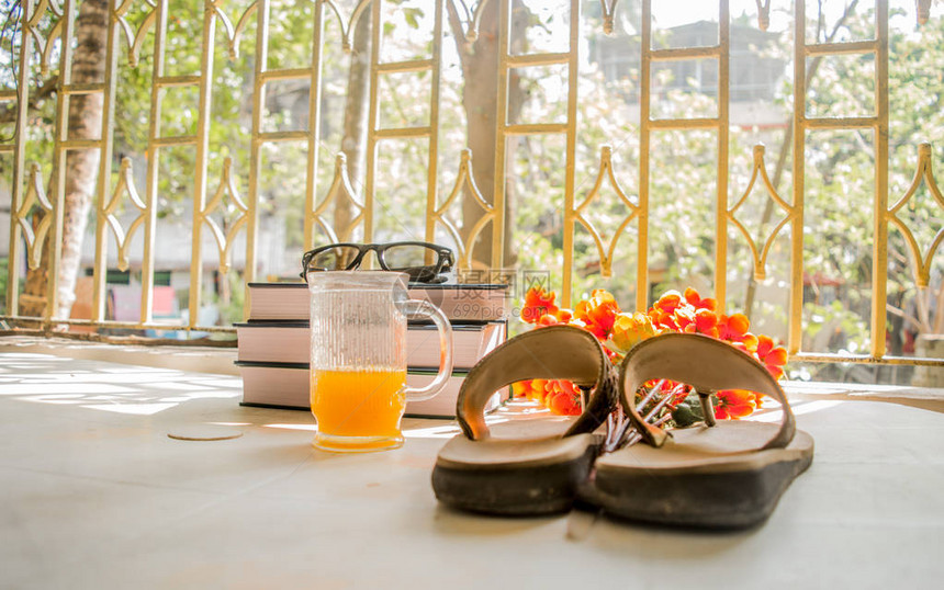 现代女假期必不可少的周日夏季周末活动在木桌上放置在书籍人字拖鸡尾酒杯和花束上的太阳镜图片
