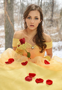 身着黄色洋装的年轻女子穿着白色背景的玫背景图片