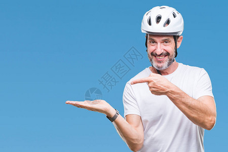 中年老骑自行车的男子穿着自行车安全头盔孤立的背景图片