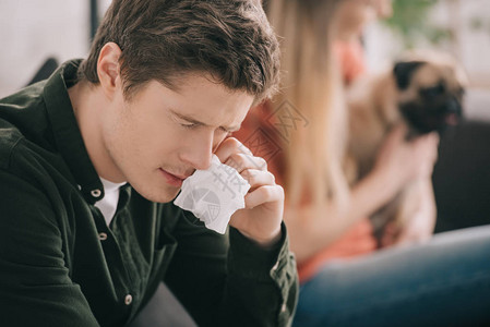 英俊男子在与女孩和小狗坐在一起时对狗组织过敏有图片