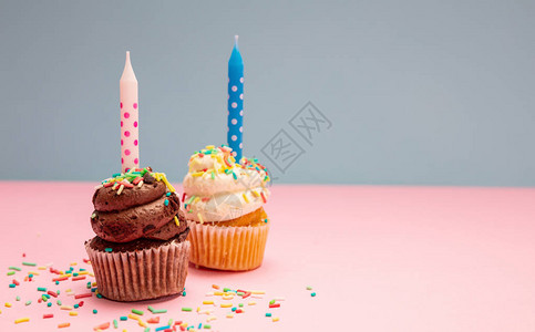 两个纸杯蛋糕香草和巧克力上面有蓝色和粉色糊面背景的蜡图片